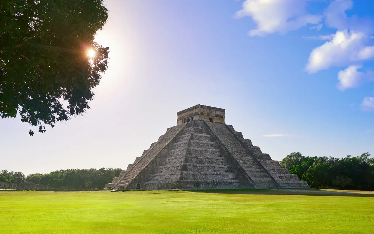 Chichen Itza ruins under a bright blue sky, a must-visit site on Cancun Mayan ruins excursions.