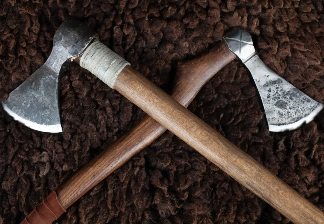 Modern replicas of Viking axes displayed alongside collectibles and Norse-inspired designs.